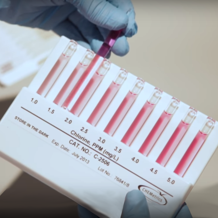 Person checking chlorine measurements using an Ozone Visual Test Kit